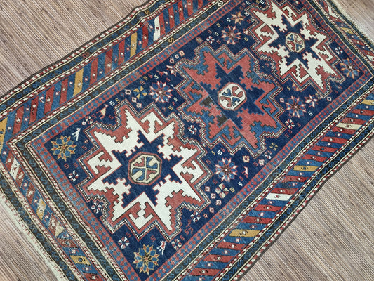Symphony of Colors: Deep blues, radiant reds, earthy browns, and delicate cream accents create a mesmerizing visual harmony in this Antique Shirvan Rug.