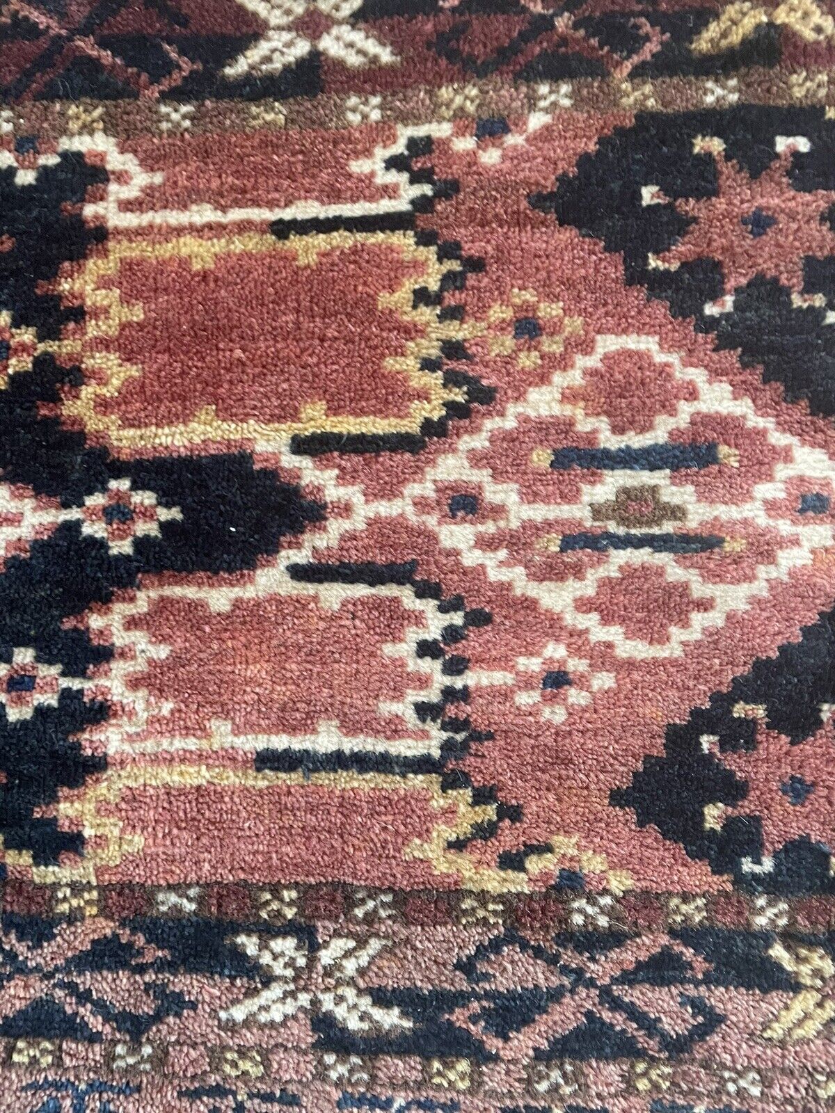 Close-up of craftsmanship on Handmade Antique Afghan Beshir Collectible Chuval Rug - Detailed view highlighting the skillful craftsmanship evident in the rug's design, despite signs of age wear.