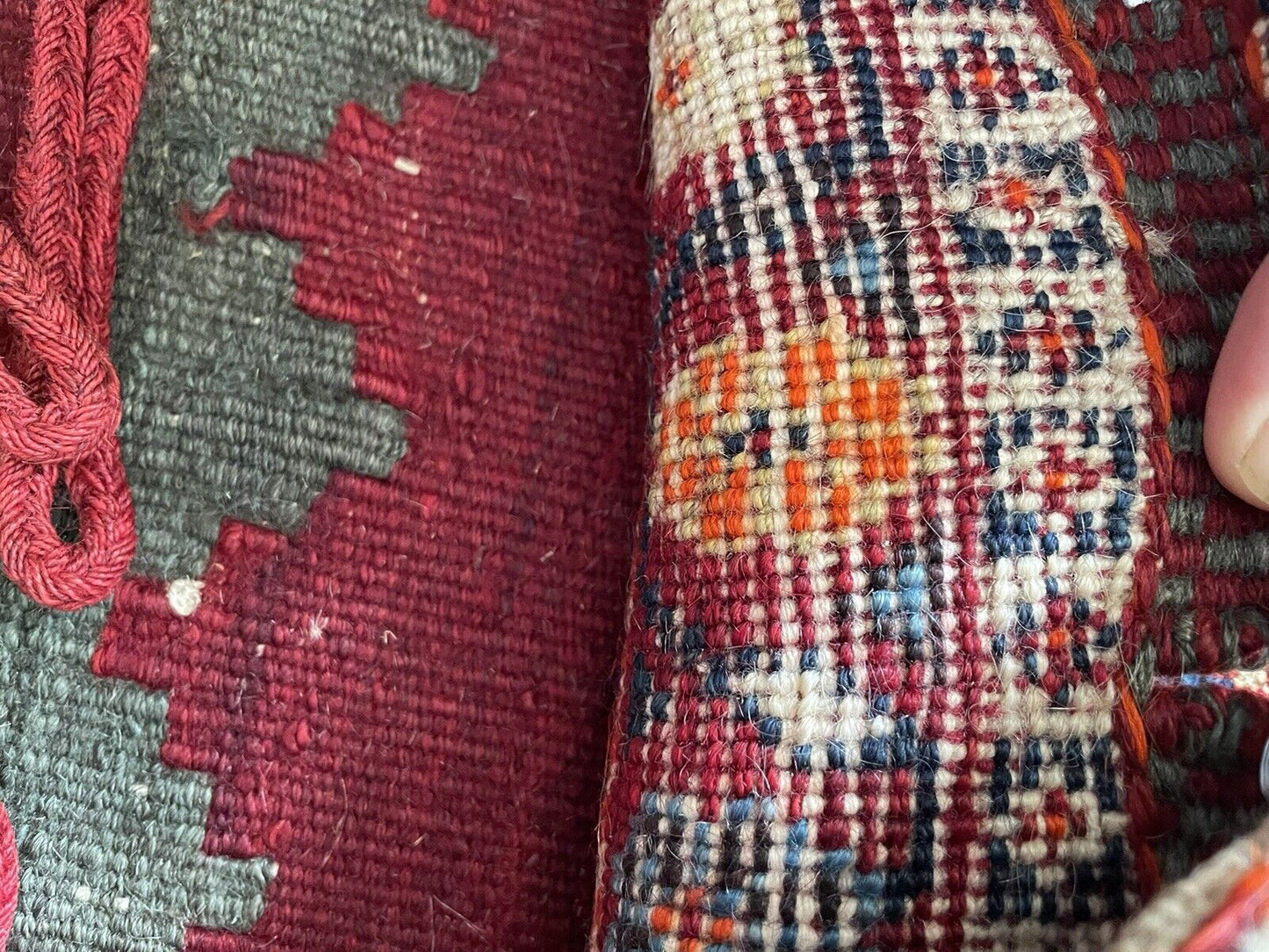 The backside of a handmade antique Persian Gashgai saddle bag (1900s), revealing the natural color and intricate web of wool threads used in its creation.