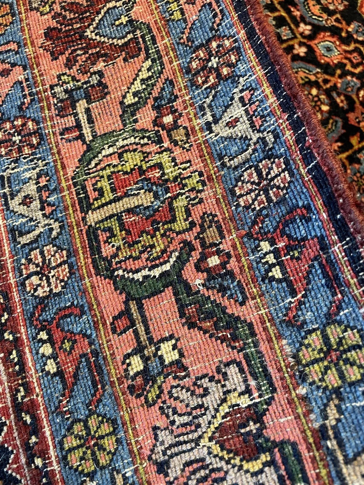 Deep red, navy blue, and beige color palette on antique Bidjar carpet