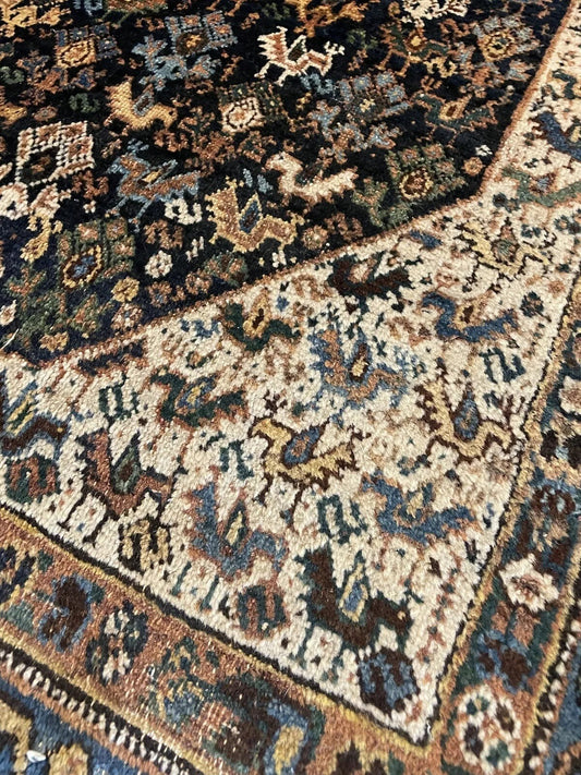 Close-up of intricate geometric and floral motifs on an antique Afshar rug