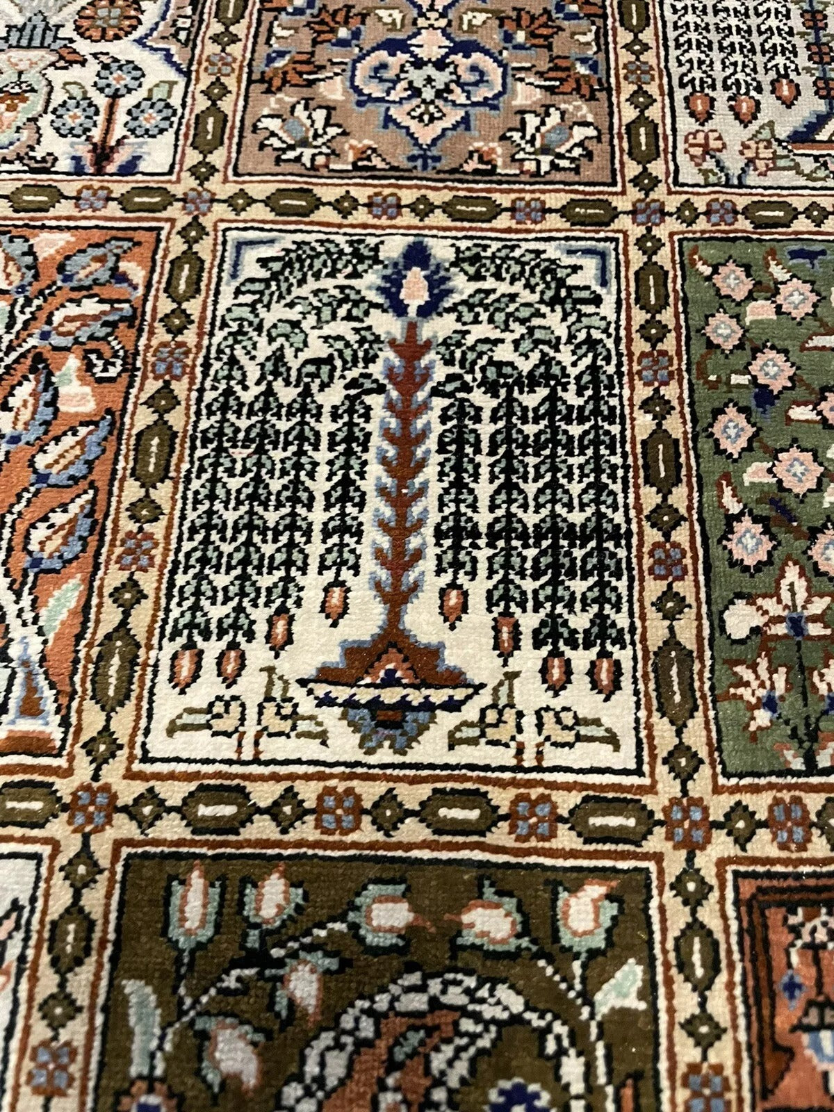 Intricate floral and geometric motifs on a Persian Qum rug