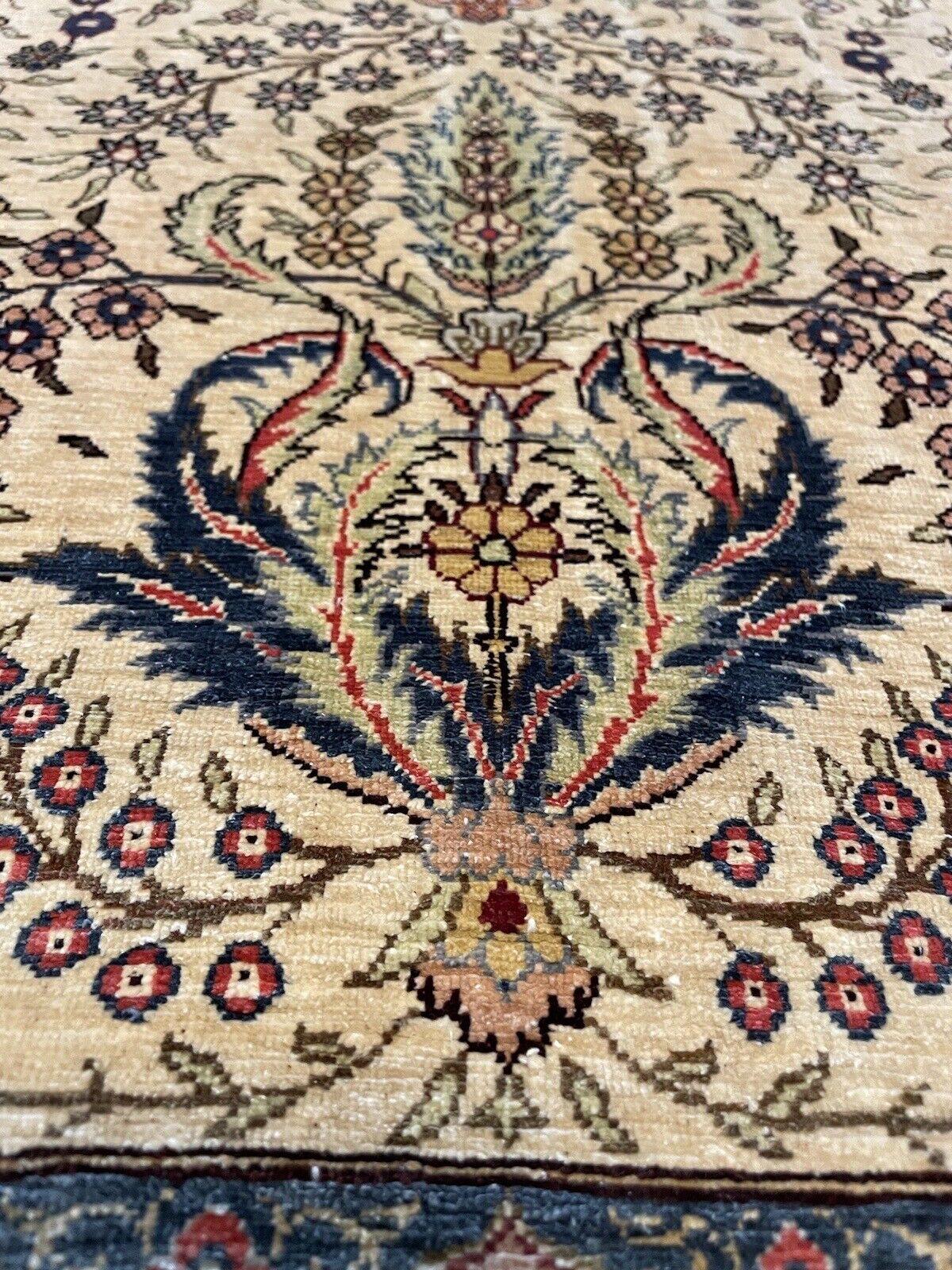 Close-up of silk texture and intricate motifs in a Hereke prayer rug