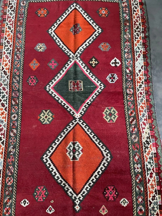 Geometric diamond motifs on a Persian Gabbeh rug with red and multicolored details