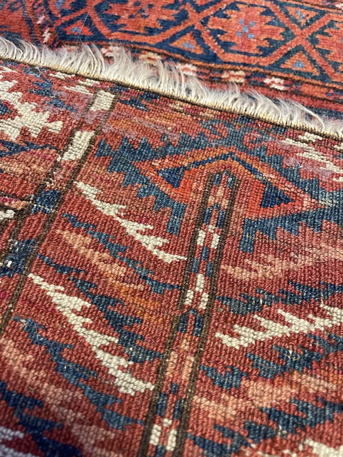 Geometric tribal motifs on an antique Turkmen Engsi rug