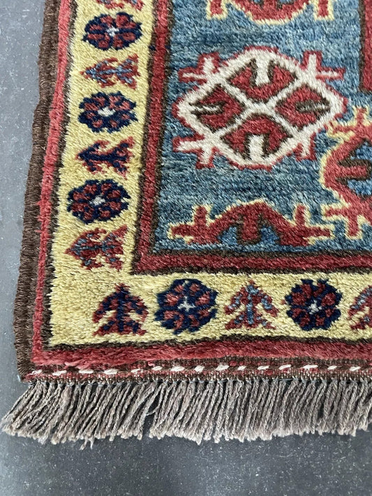 Close-up of geometric motifs on a vintage Kazak rug