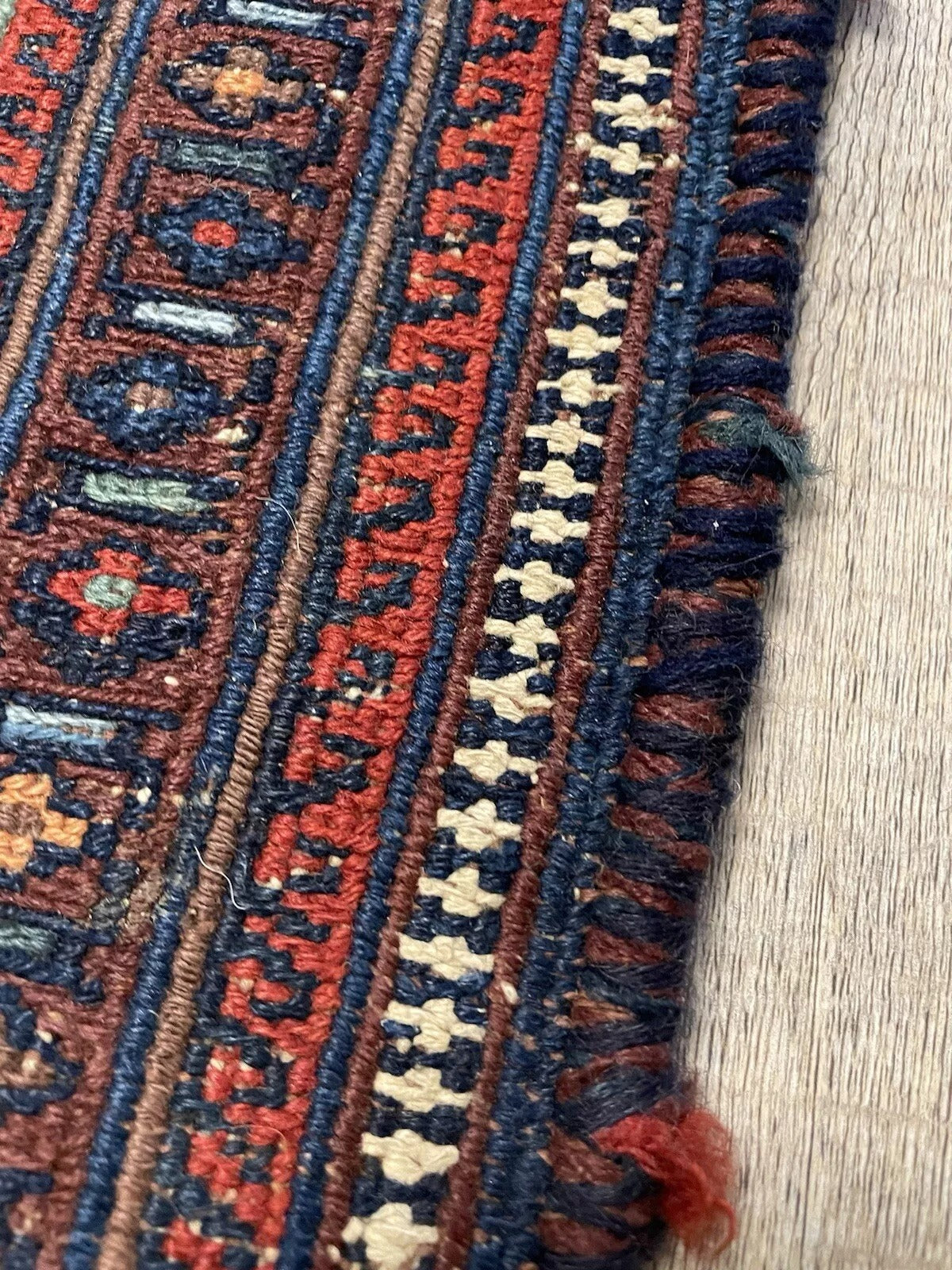 Sumak rug with finely detailed border and deep red tribal motifs