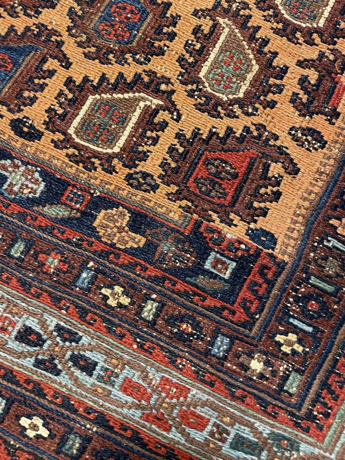 Close-up of intricate patterns on a traditional handwoven Afghan Sumak rug