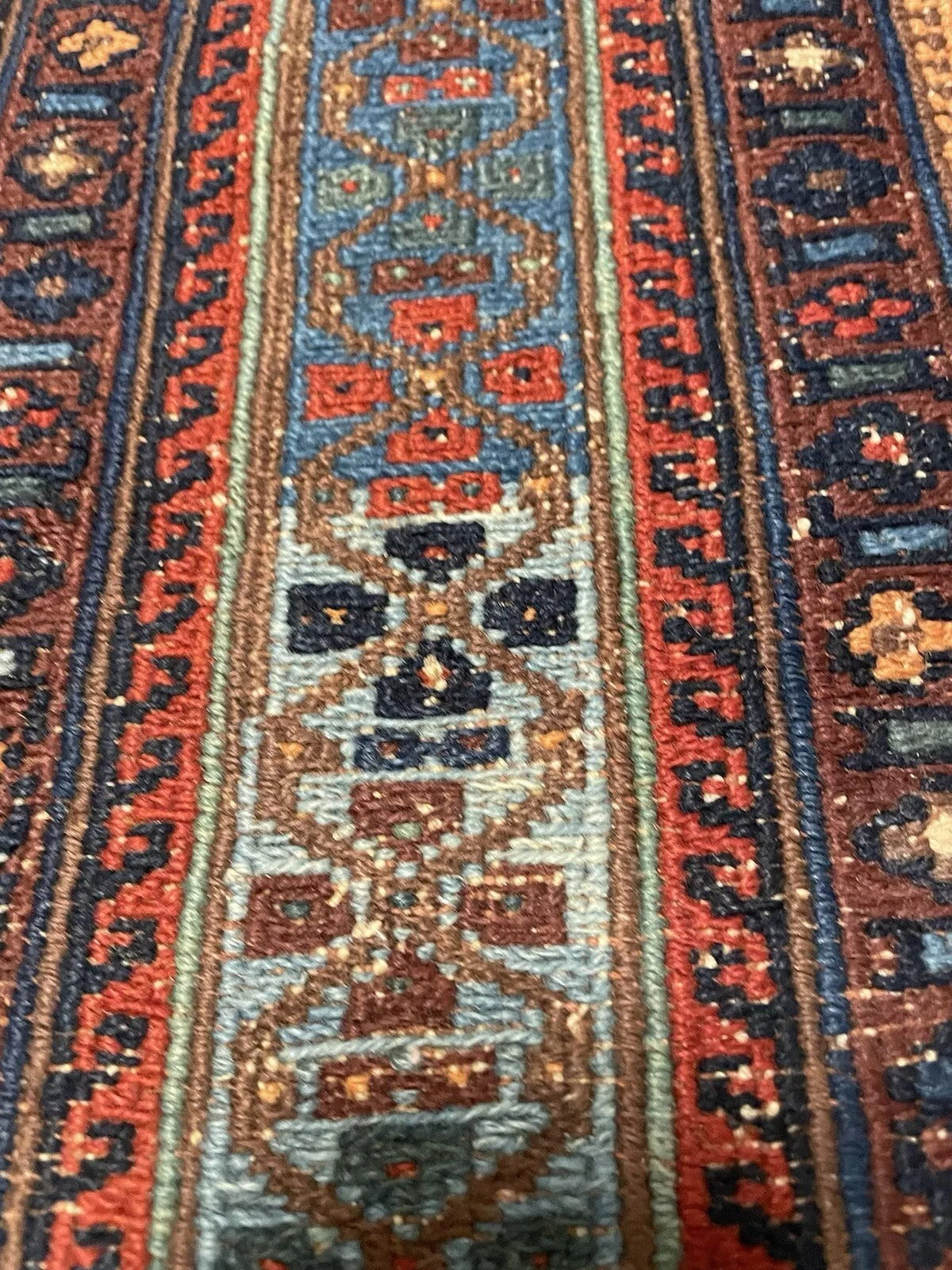 Aged wool fibers and flatweave texture of a vintage Sumak rug