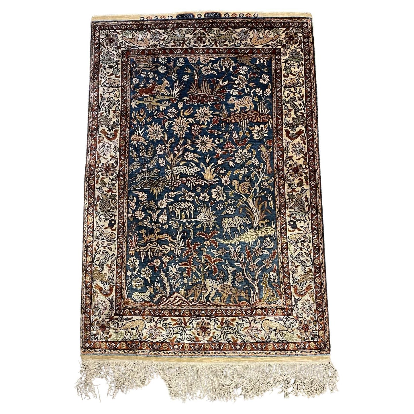 Handmade vintage Turkish Hereke silk rug with floral and animal motifs.