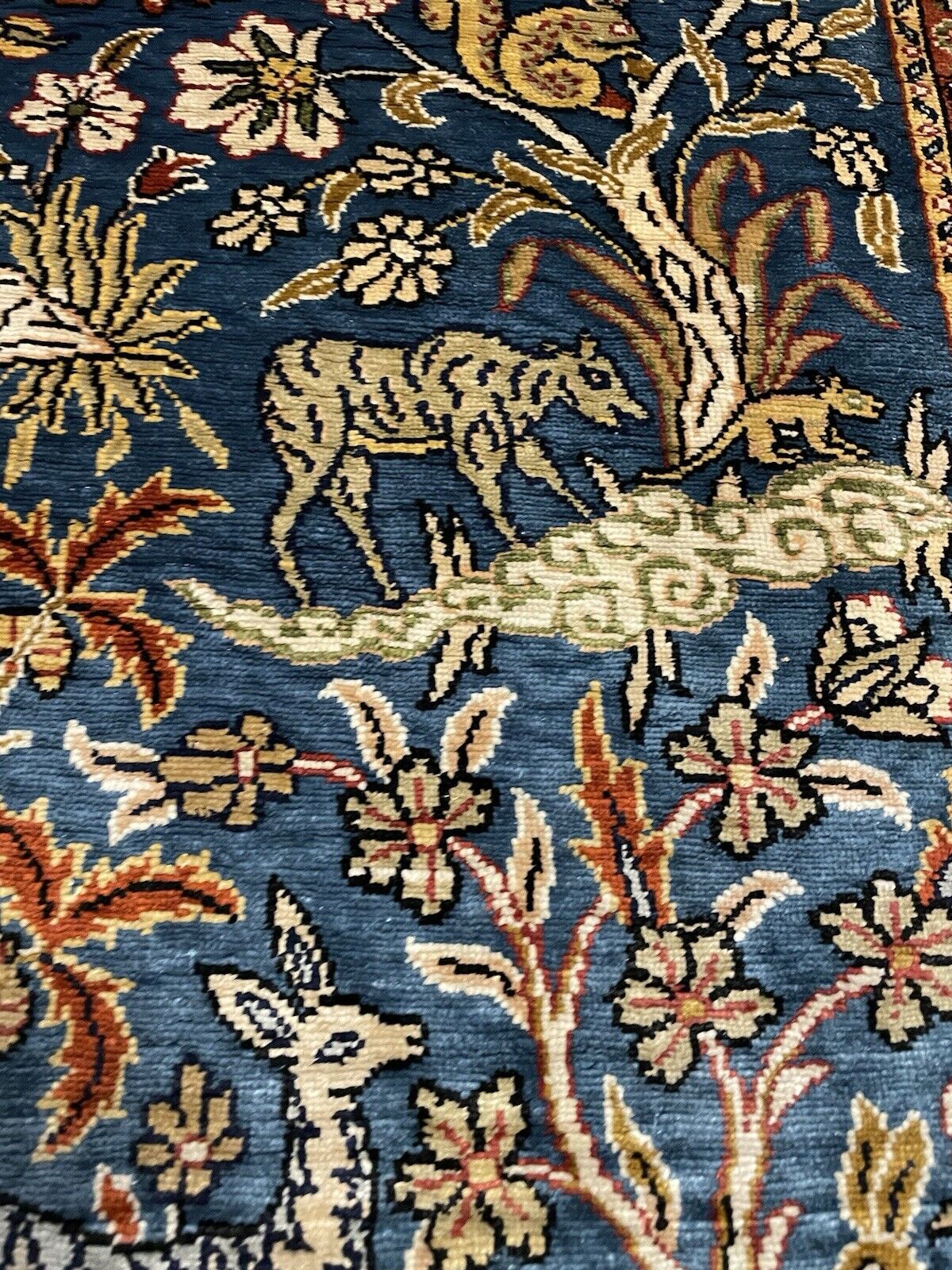 Dark blue background of a vintage silk Hereke carpet.