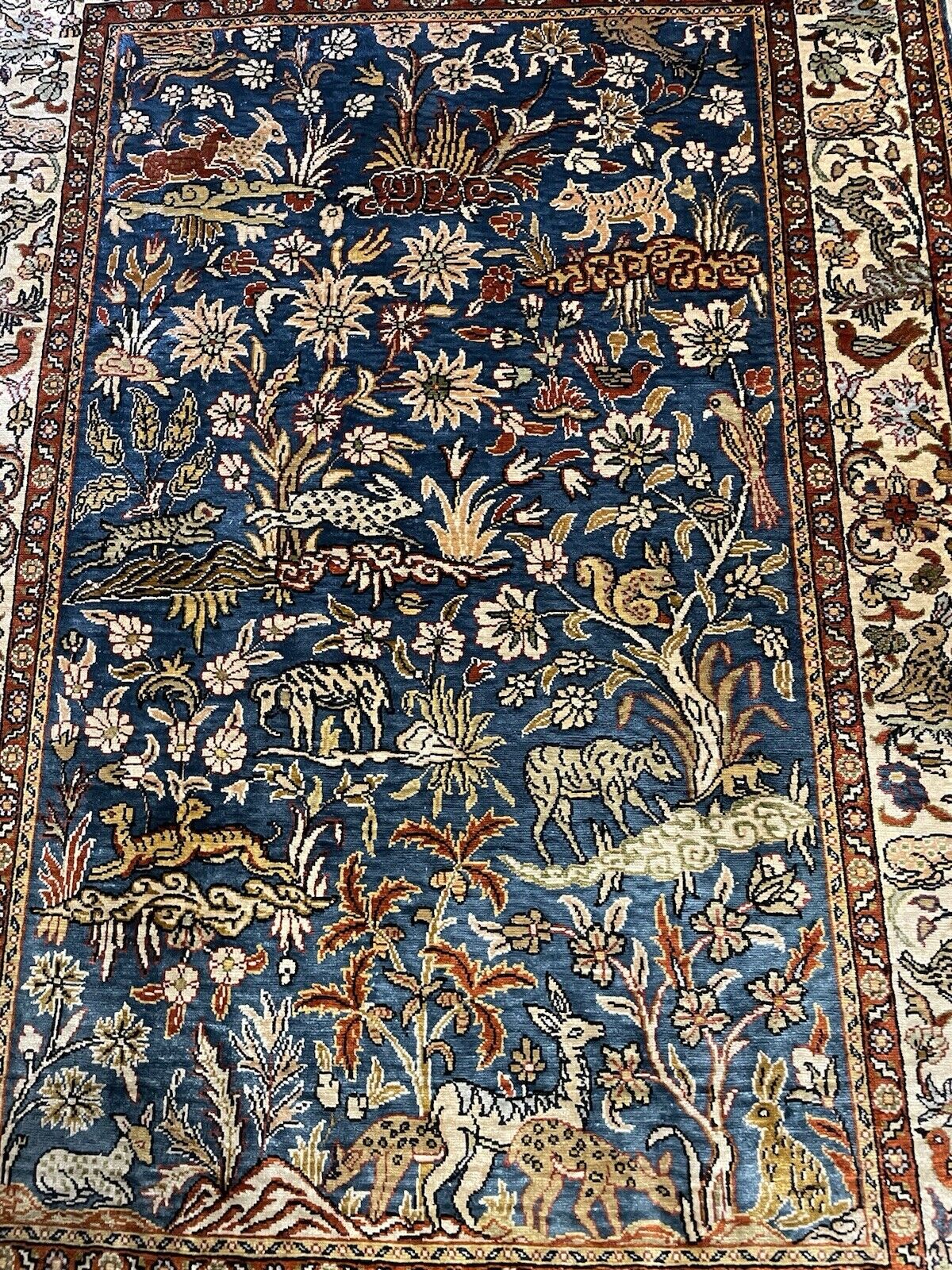Close-up of delicate floral details on a handmade silk rug.