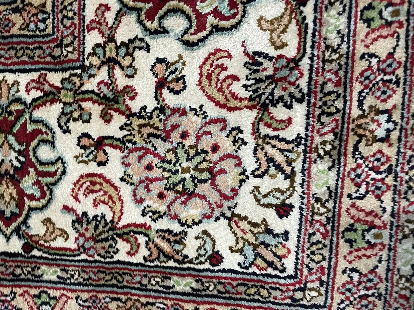 Detailed floral border of Persian Qum rug from 1970s