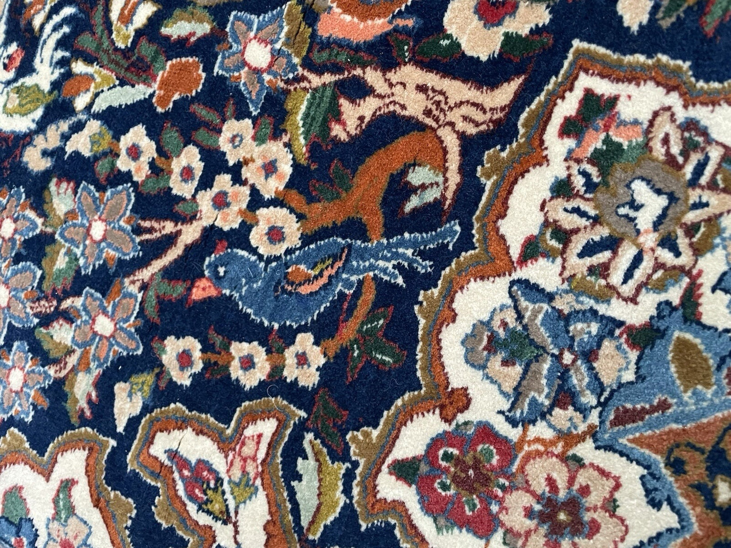 Persian rug with balanced color palette of navy blue, ivory, and gold