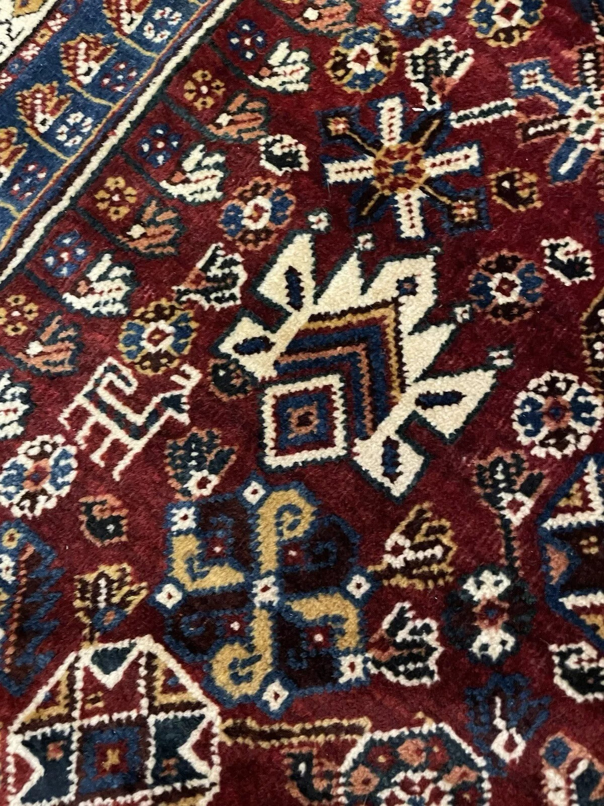 Corner of Gashkai rug showing animal and human motifs