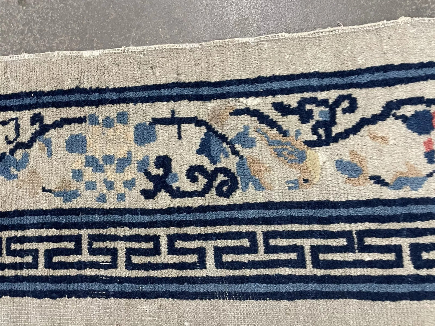 Subtle fretwork border design on cream field