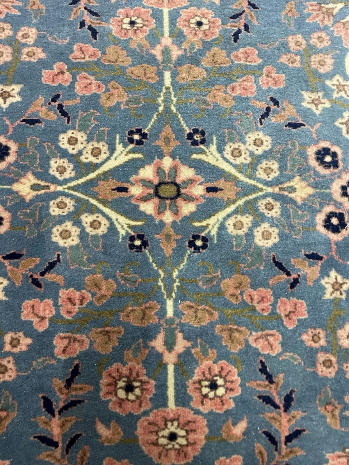 Vintage Kerman carpet detail with traditional vine motifs