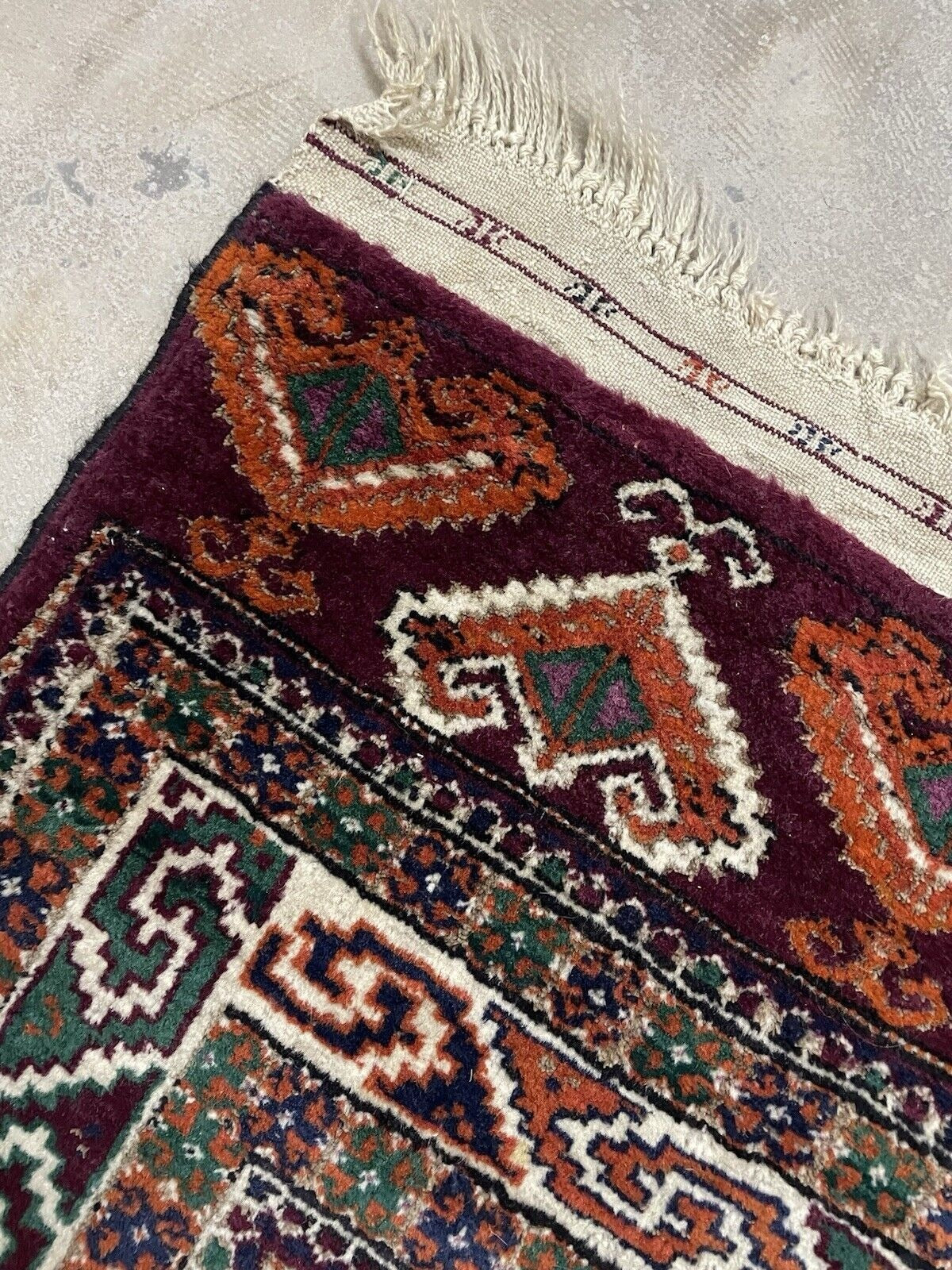 Traditional nomadic rug draped over bench