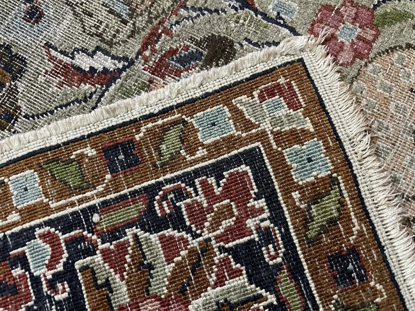 Shot focusing on a stylized bird figure within the rug's field.