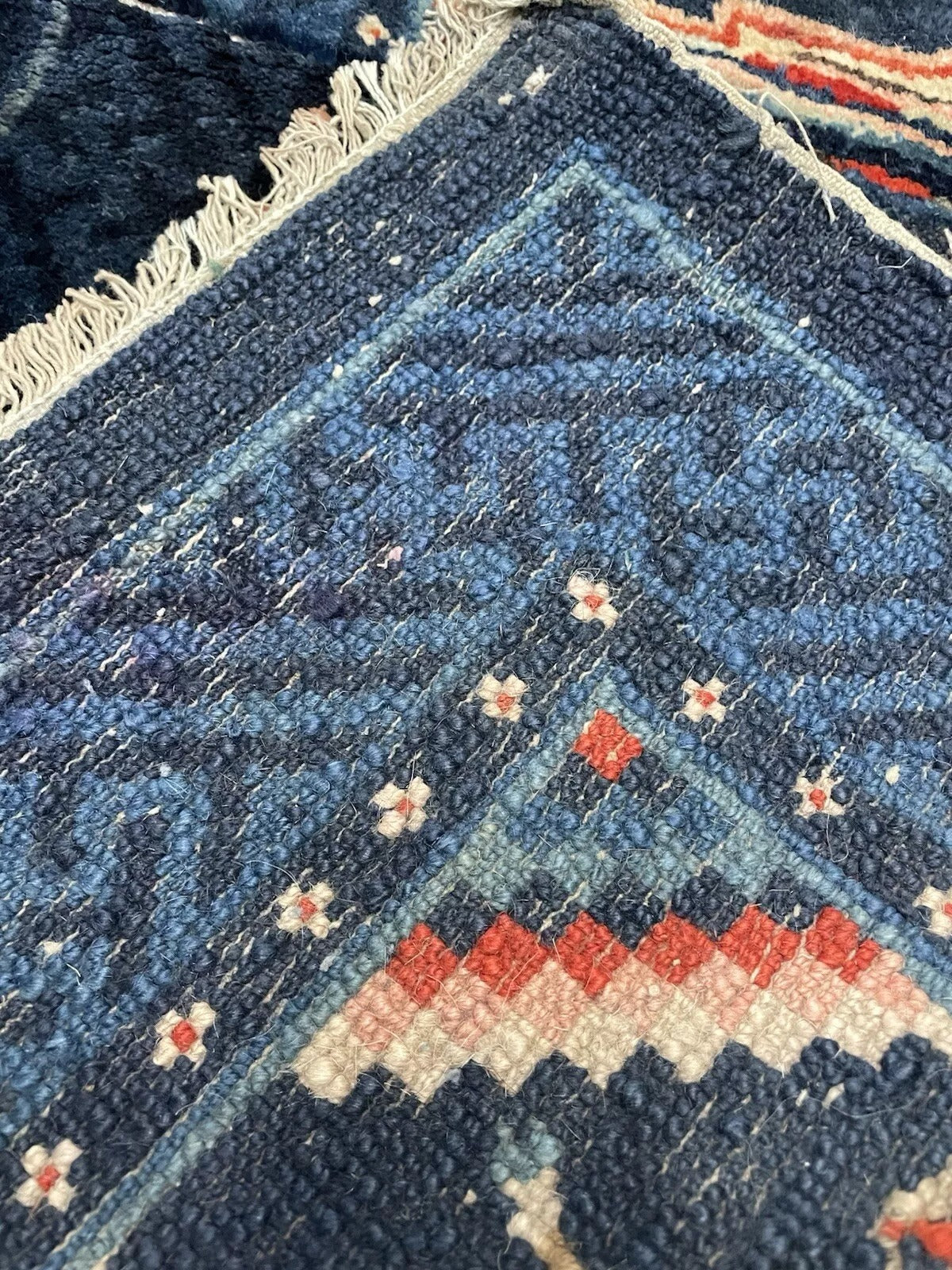 Texture shot showing the aged, high-quality wool pile of the Pao Tao carpet.