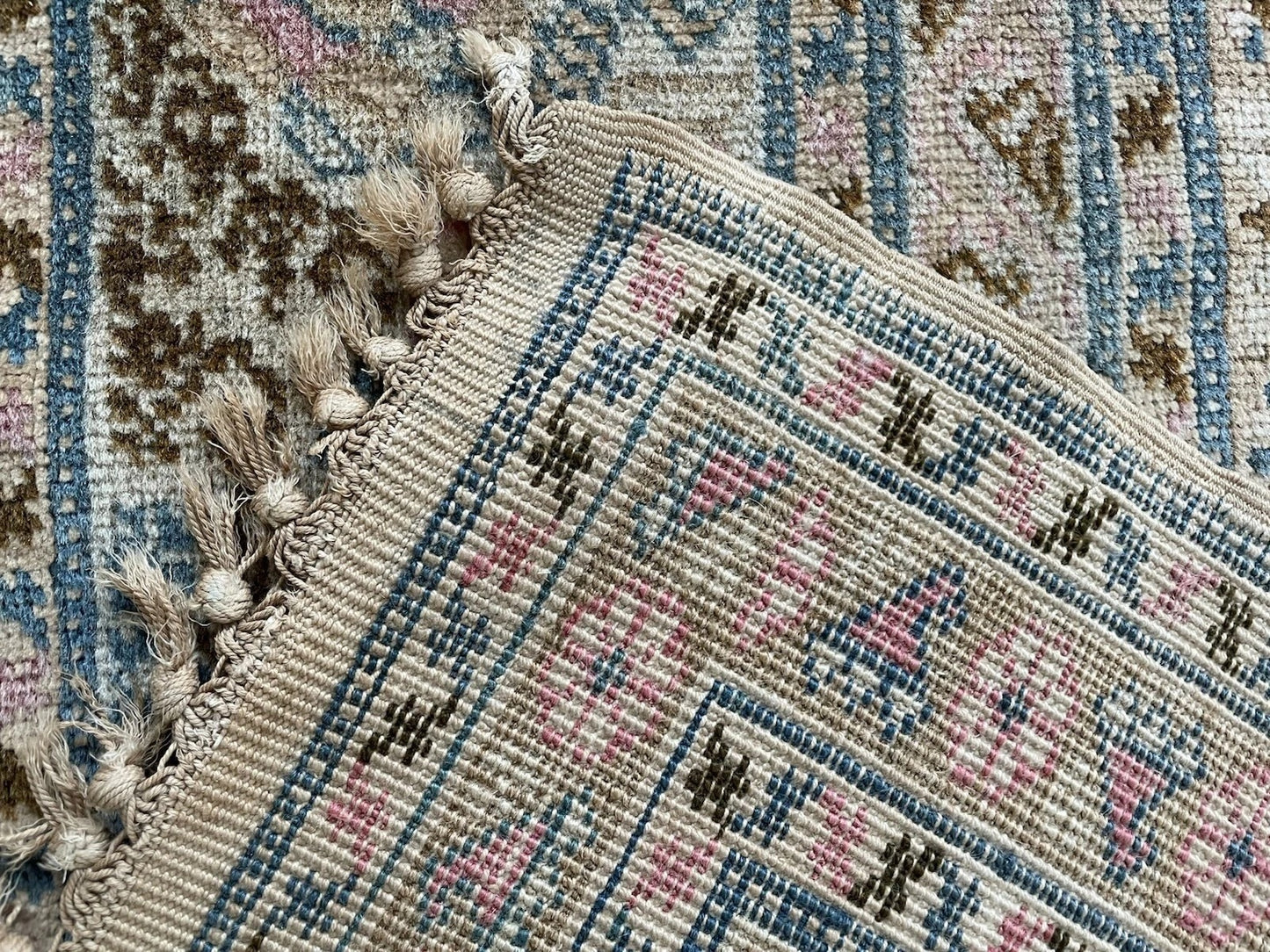 Detail highlighting the pale rose accents woven throughout the design.