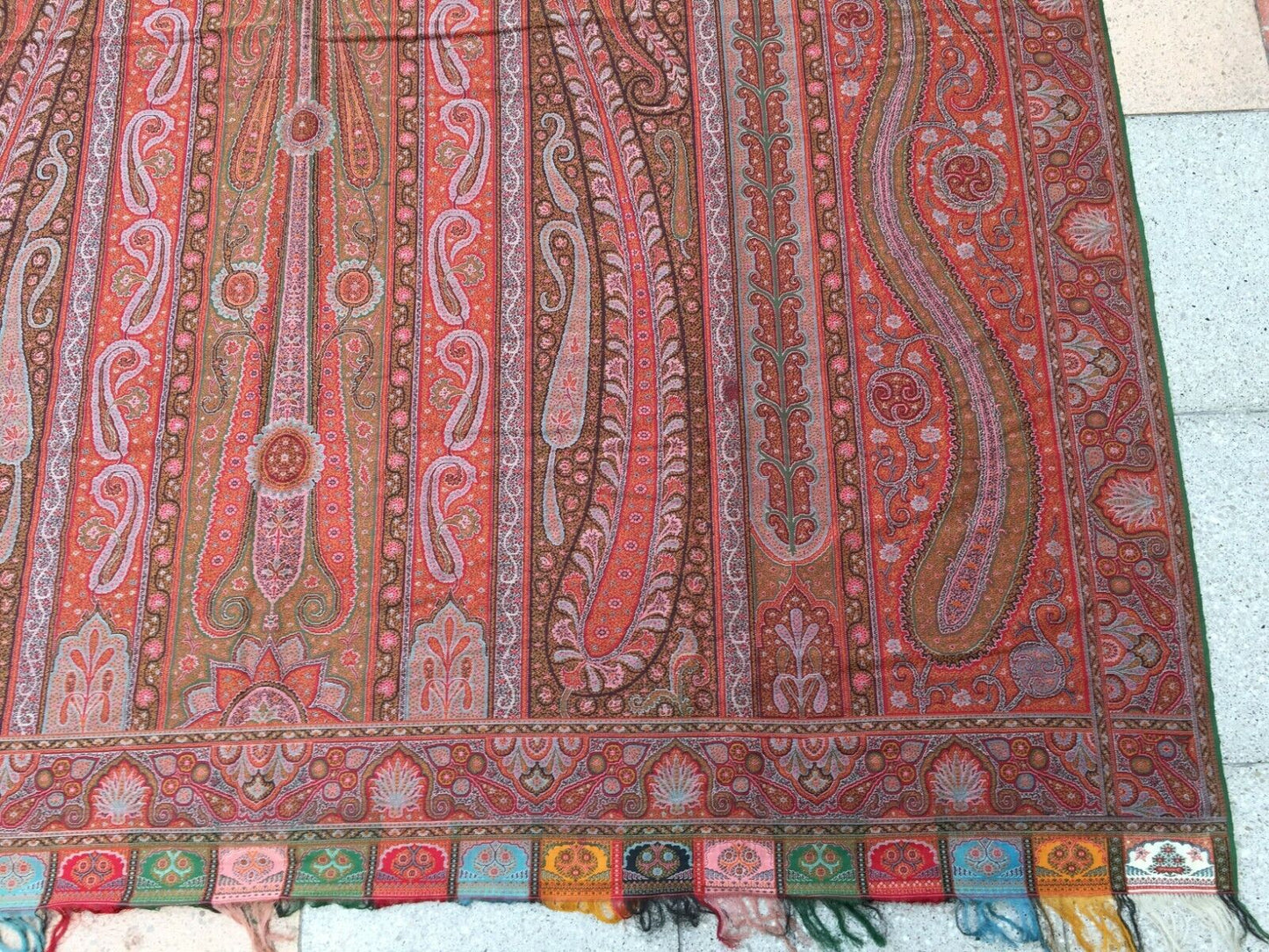 Overhead shot of the shawl showcasing its vibrant red color with black, white, and beige accents