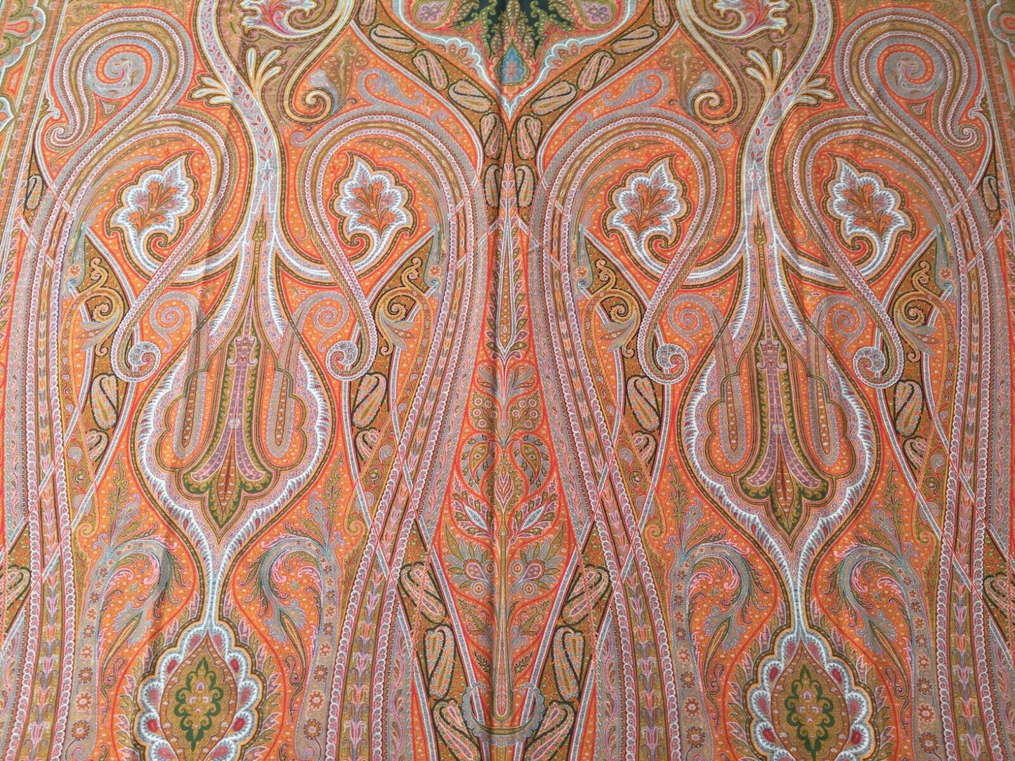Overhead shot of the shawl showcasing its warm orange and red tones with interspersed lighter shades