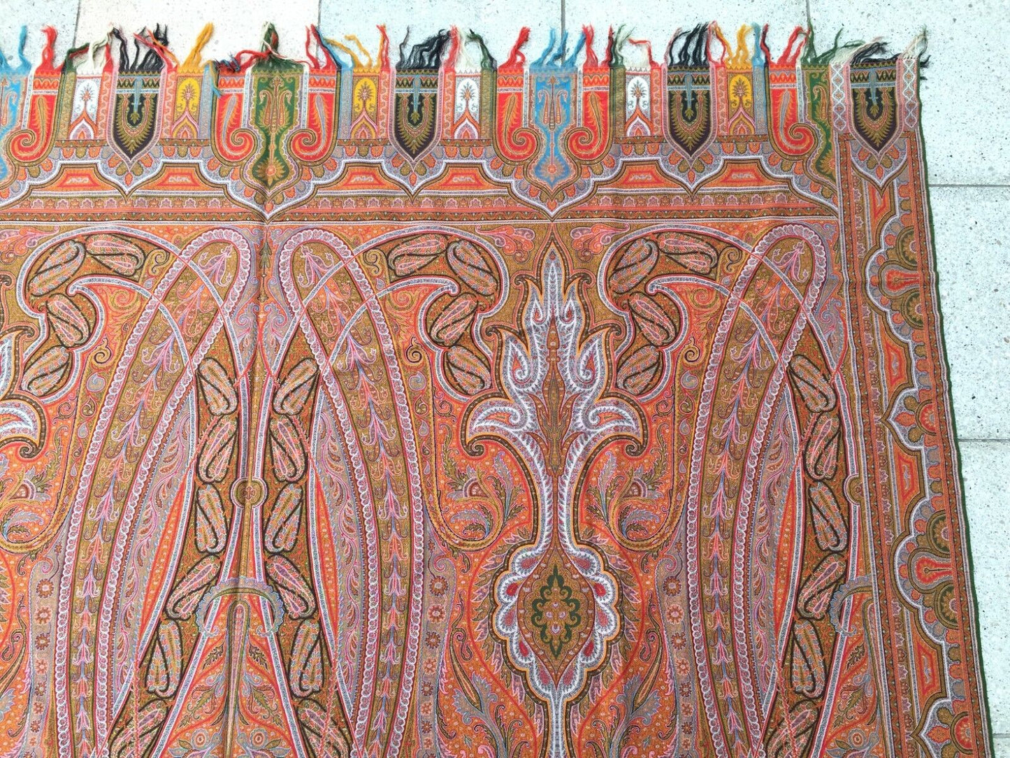 Artistic display of the shawl as a statement piece on a clothing rack, showcasing its vibrant colors and intricate patterns
