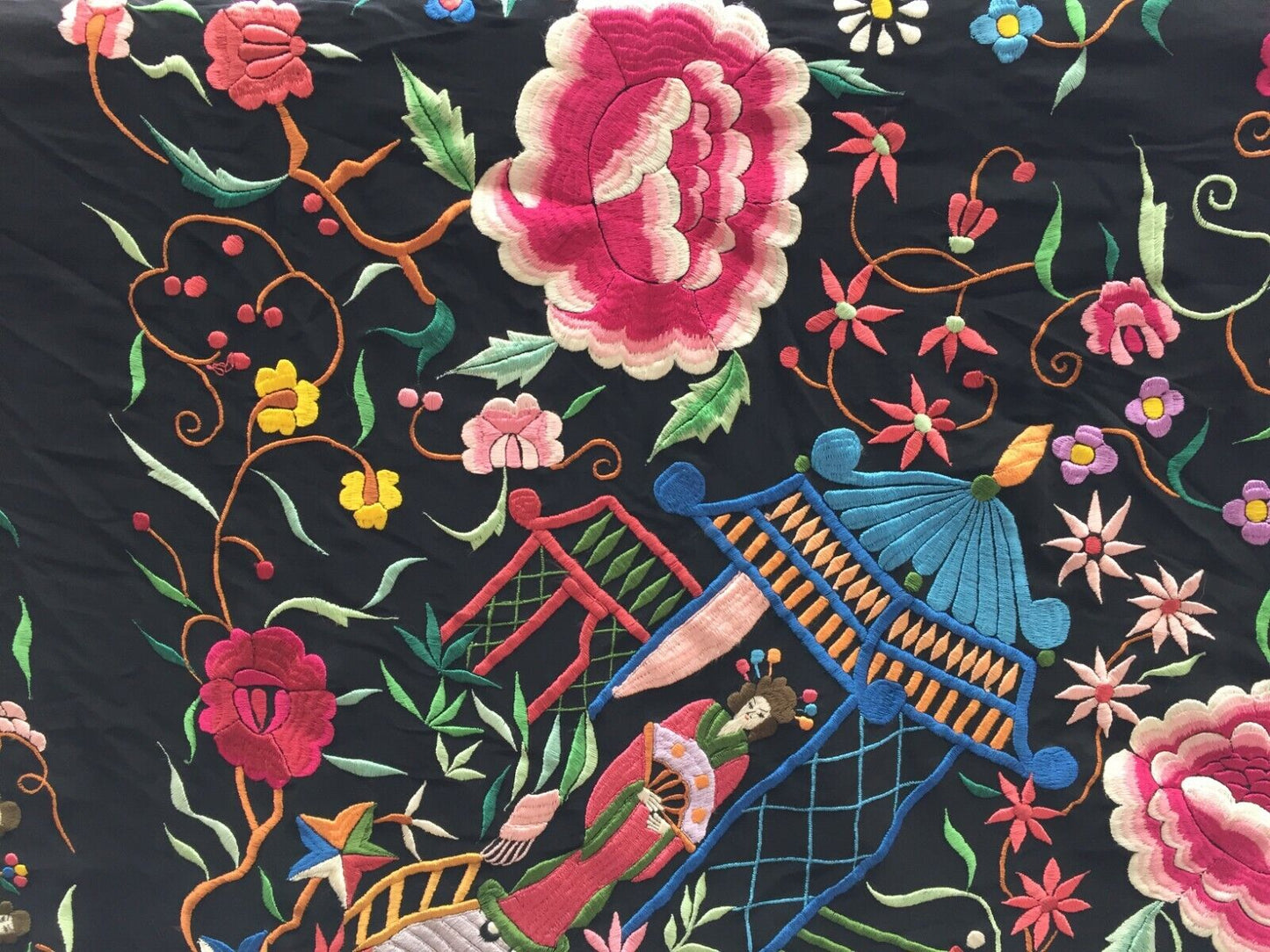 Artistic display of the shawl as a statement piece on a clothing rack, showcasing its dramatic black color and intricate embroideries