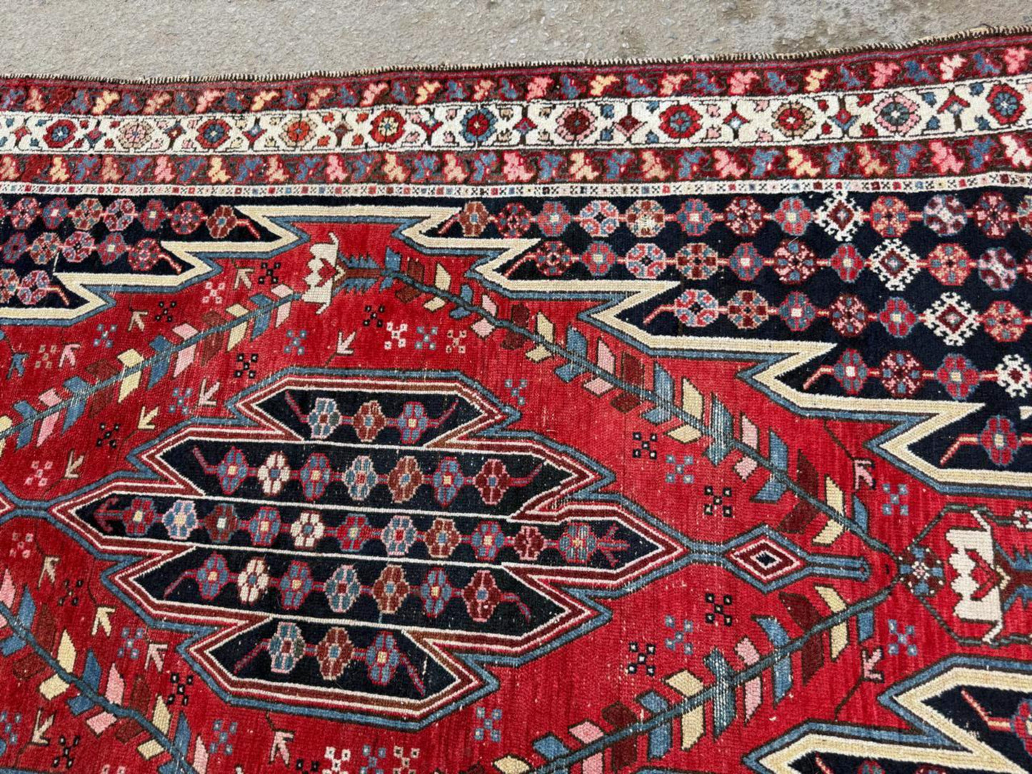Detail of the deep indigo blue and brick red elements in the design.