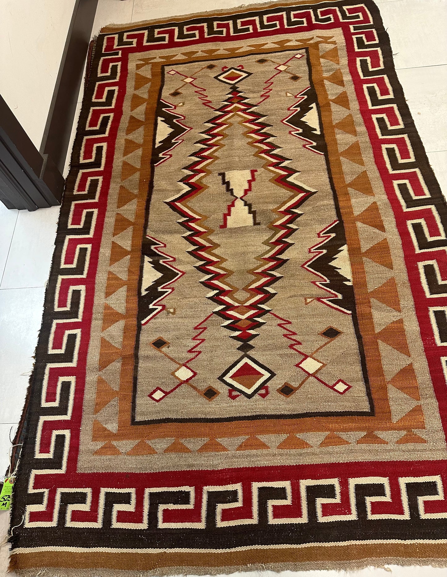 Close-up of bold red border with stepped key motifs on Navajo rug.