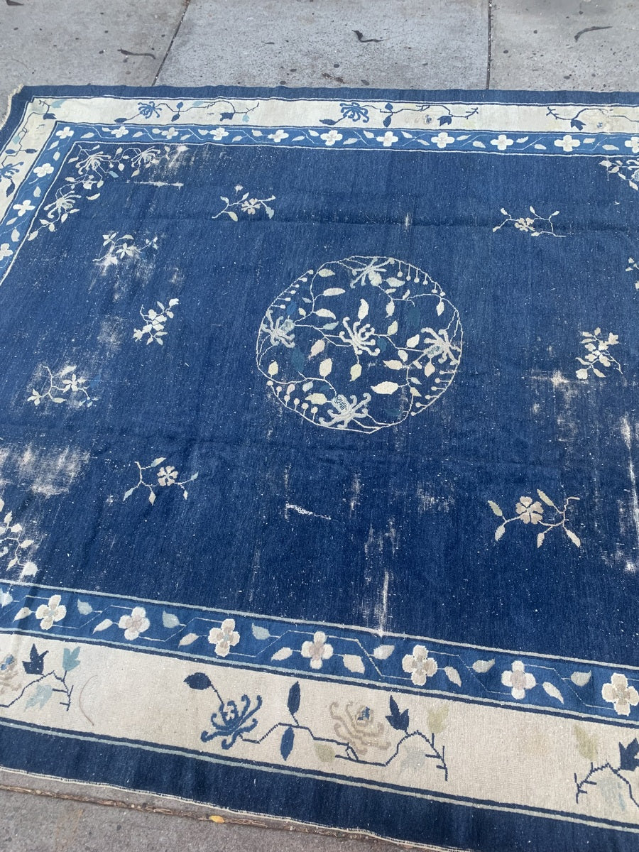 Large antique Chinese rug with intricate floral and geometric patterns.