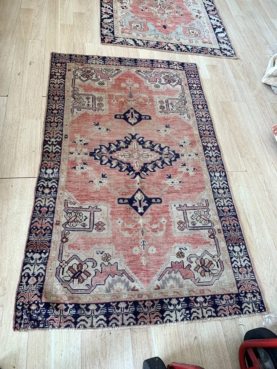 Soft antique rose and deep navy blue color palette on the vintage rug.