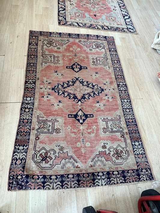 Soft antique rose and deep navy blue color palette on the vintage rug.