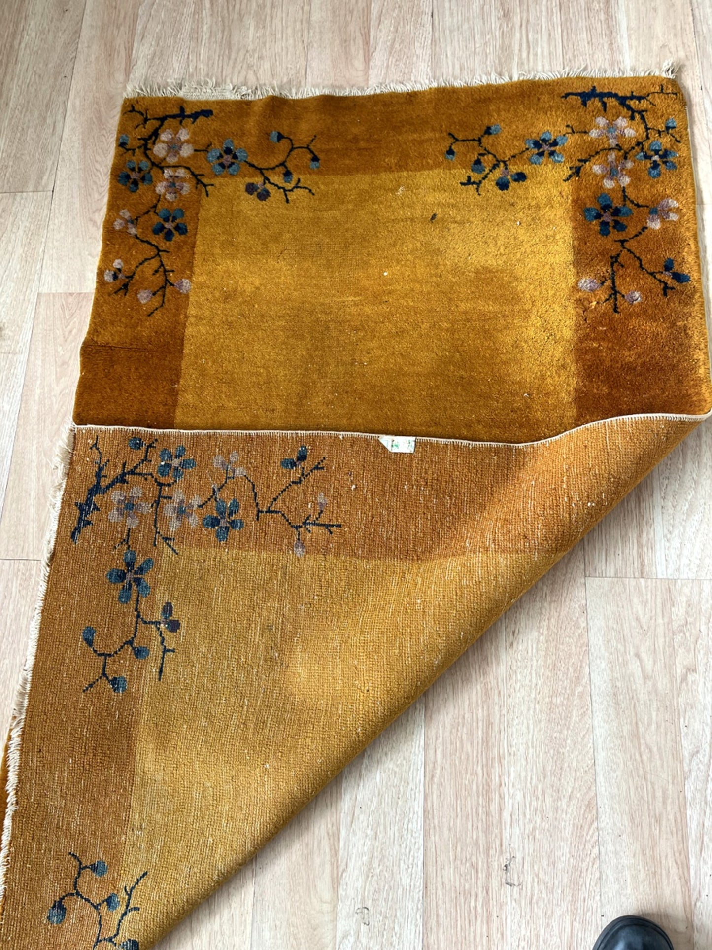 Intricate floral detailing symmetrically placed across the rug