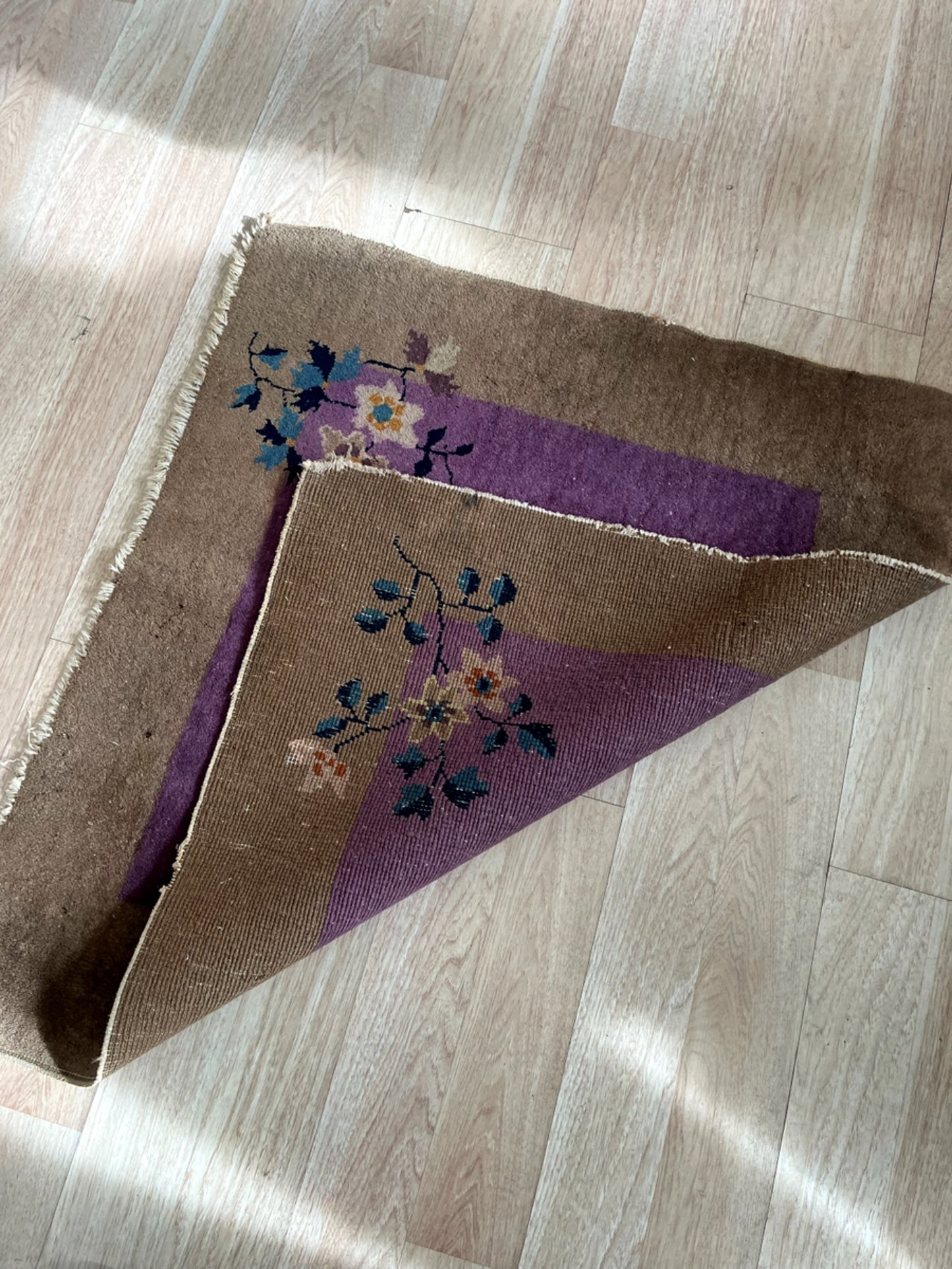 Rich purple central field with a warm brown border on the Art Deco rug