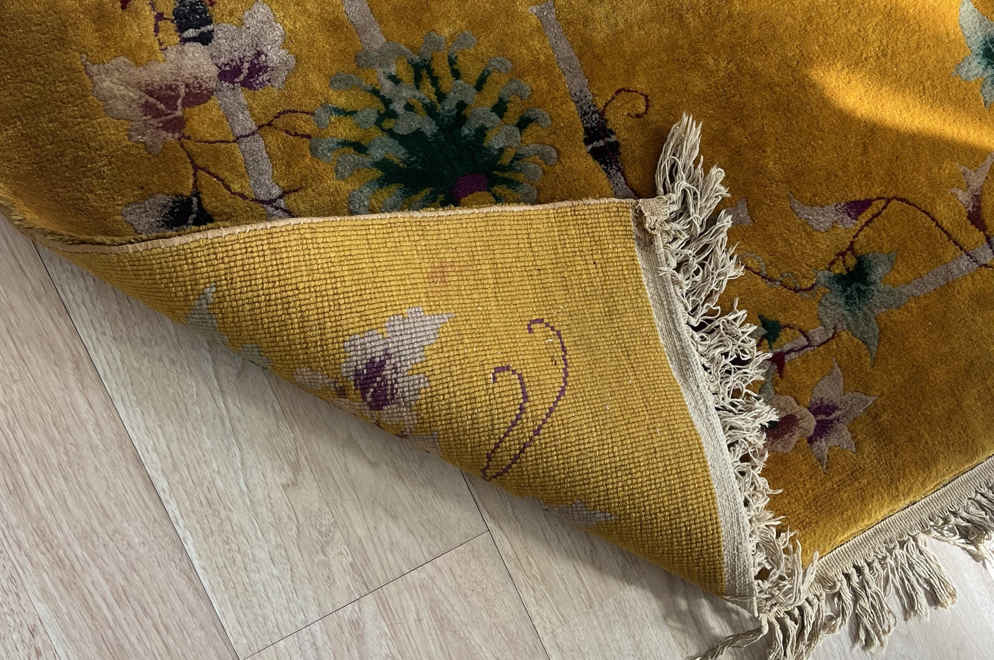 Side angle of the antique wool rug showcasing detailed patterns