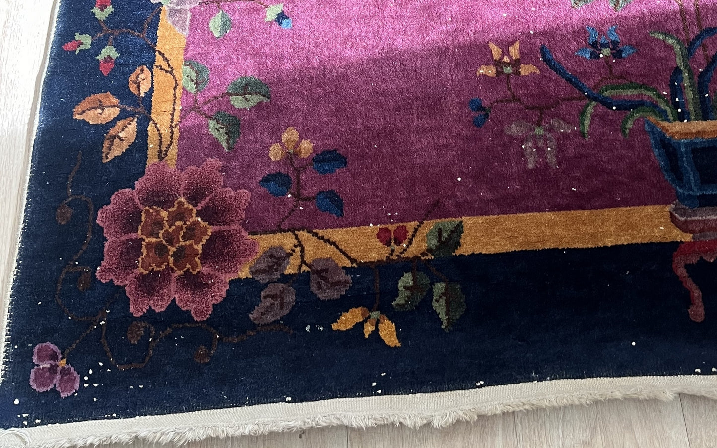 Magenta central field with intricate floral patterns on Art Deco rug