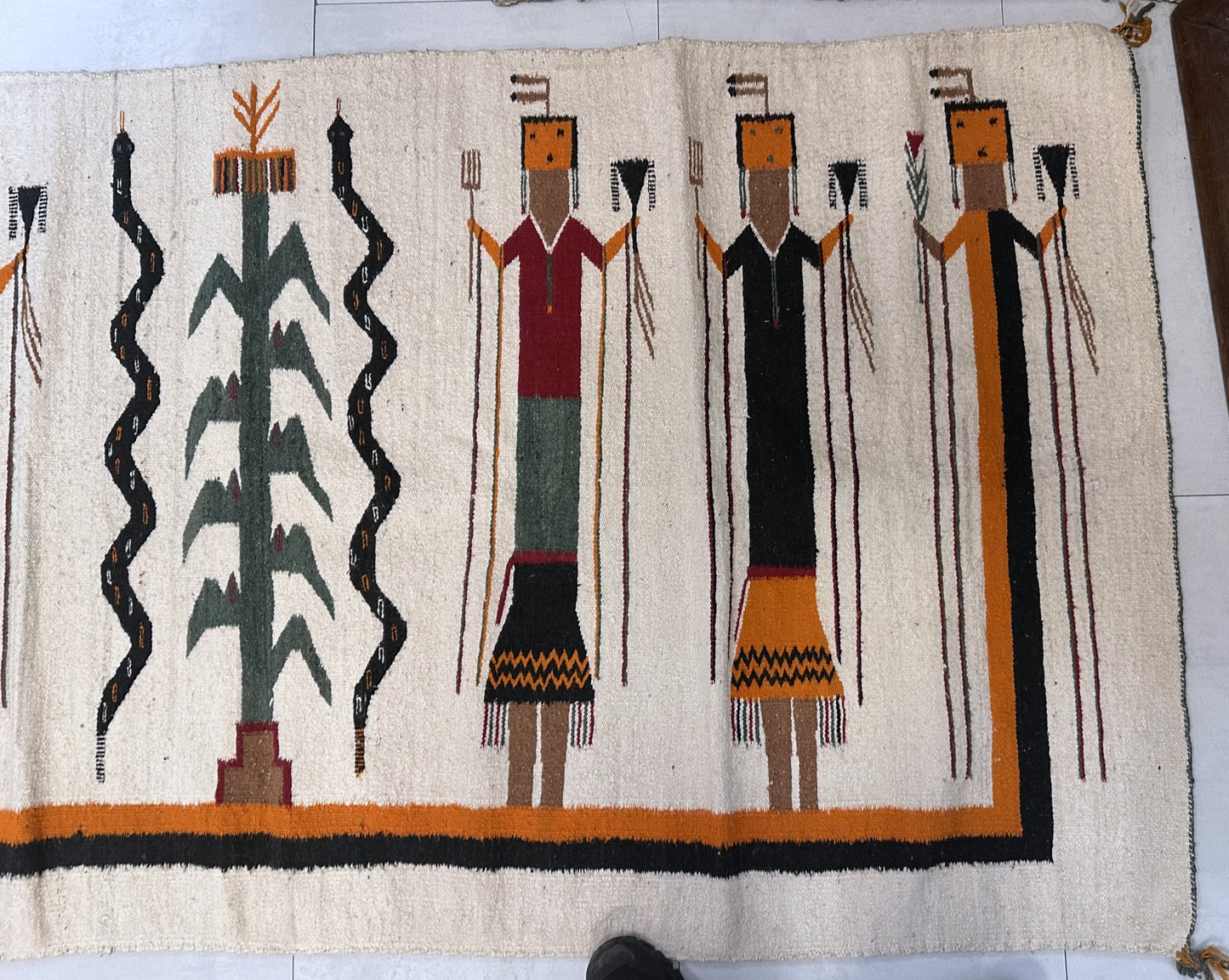 Textile with stylized figures and abstract patterns on a beige background