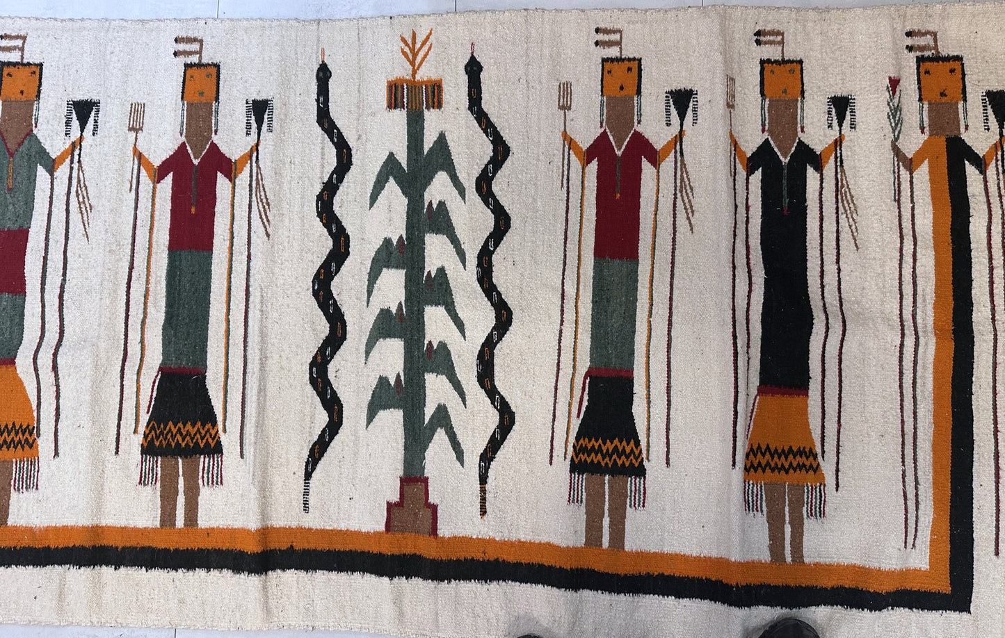 Textile with stylized figures and abstract designs on a white background