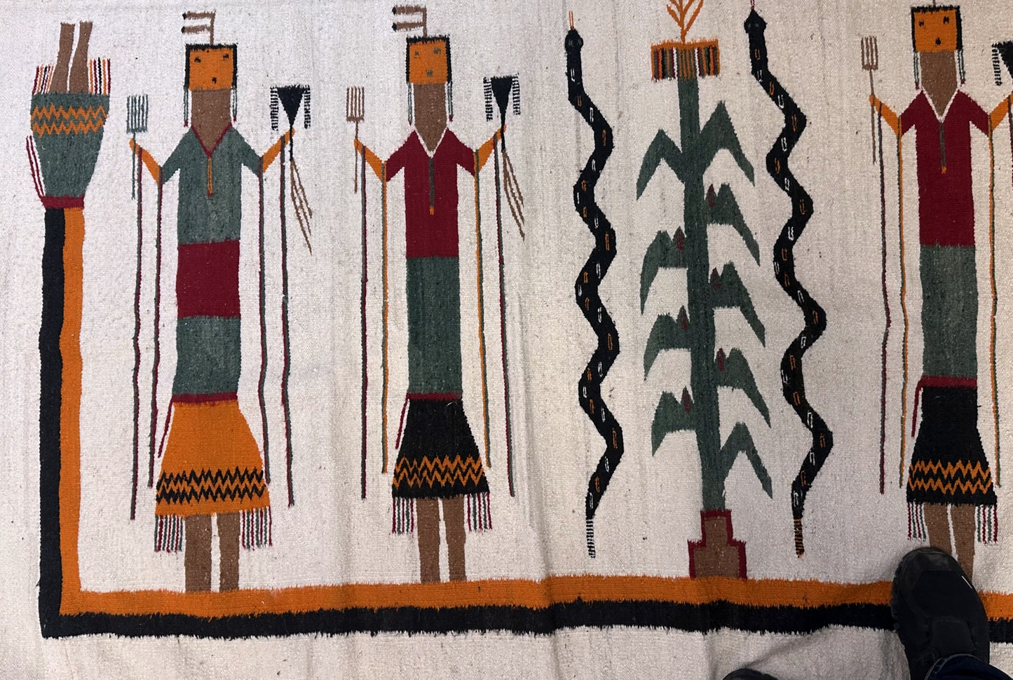 Textile with stylized figures and patterns on a white background