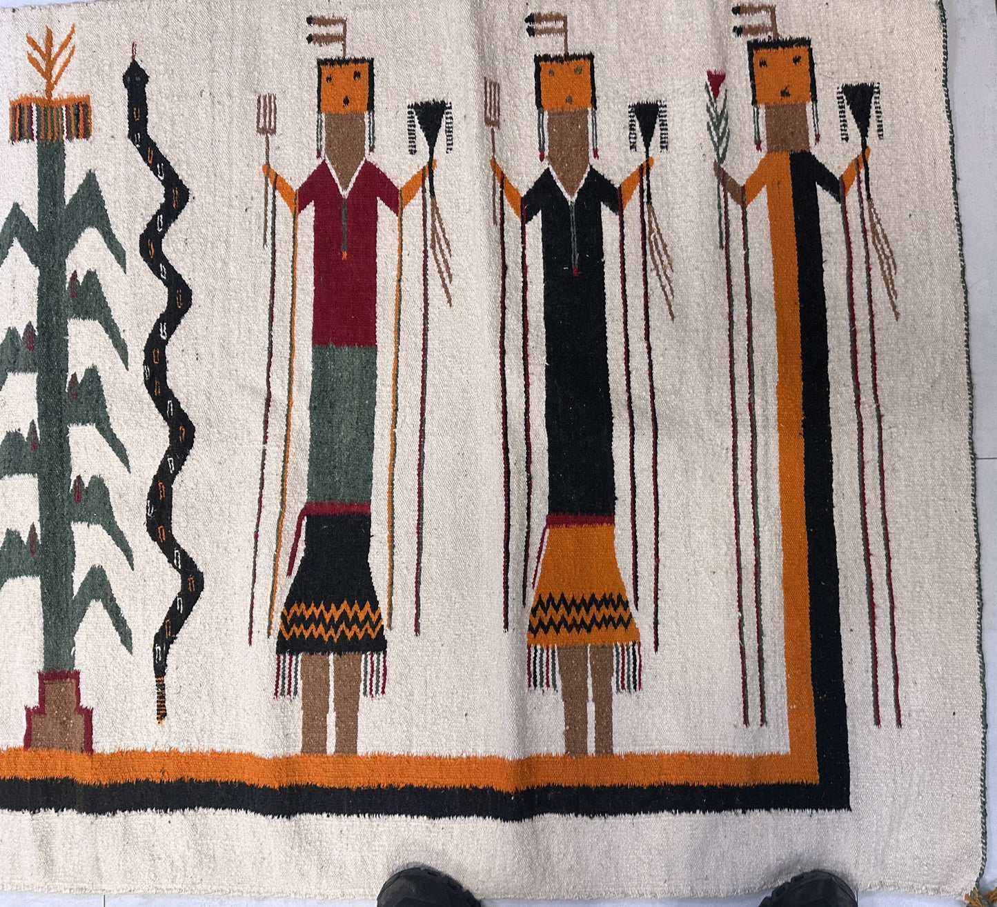 Hand-woven antique Navajo rug with spiritual figures.