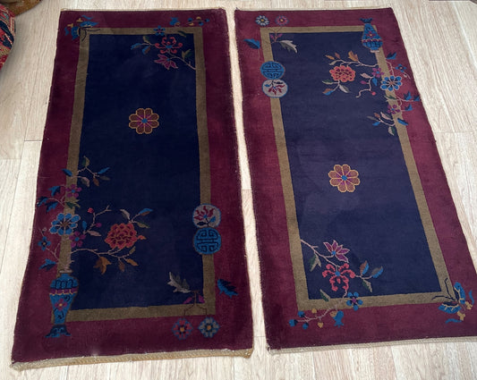 Close-up detail of the indigo field and aubergine border on one rug.