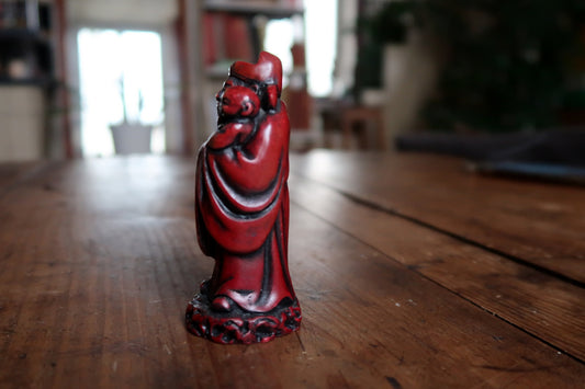 Side view showing child above deep red robe folds