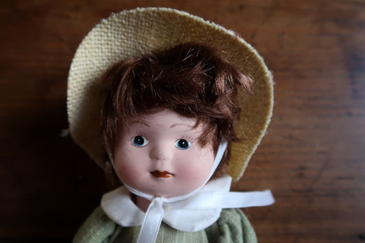 Brown fabric-covered doll shoes with golden-brown ribbon ties beneath white bloomers.