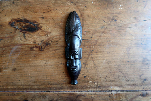 West African tribal mask — ebonized wood carving featuring raised herringbone leaf motif