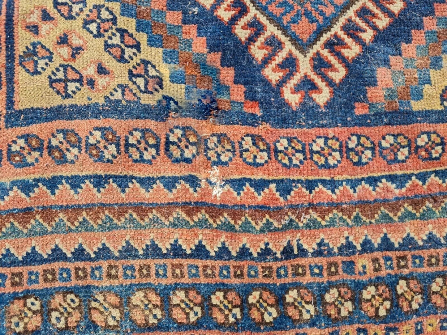 Distressed detail showing natural aging on antique rug