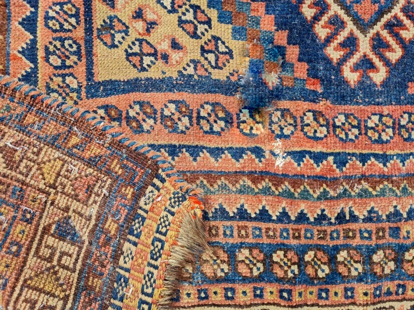 Corner detail of vintage Qashqai rug with ivory fringe