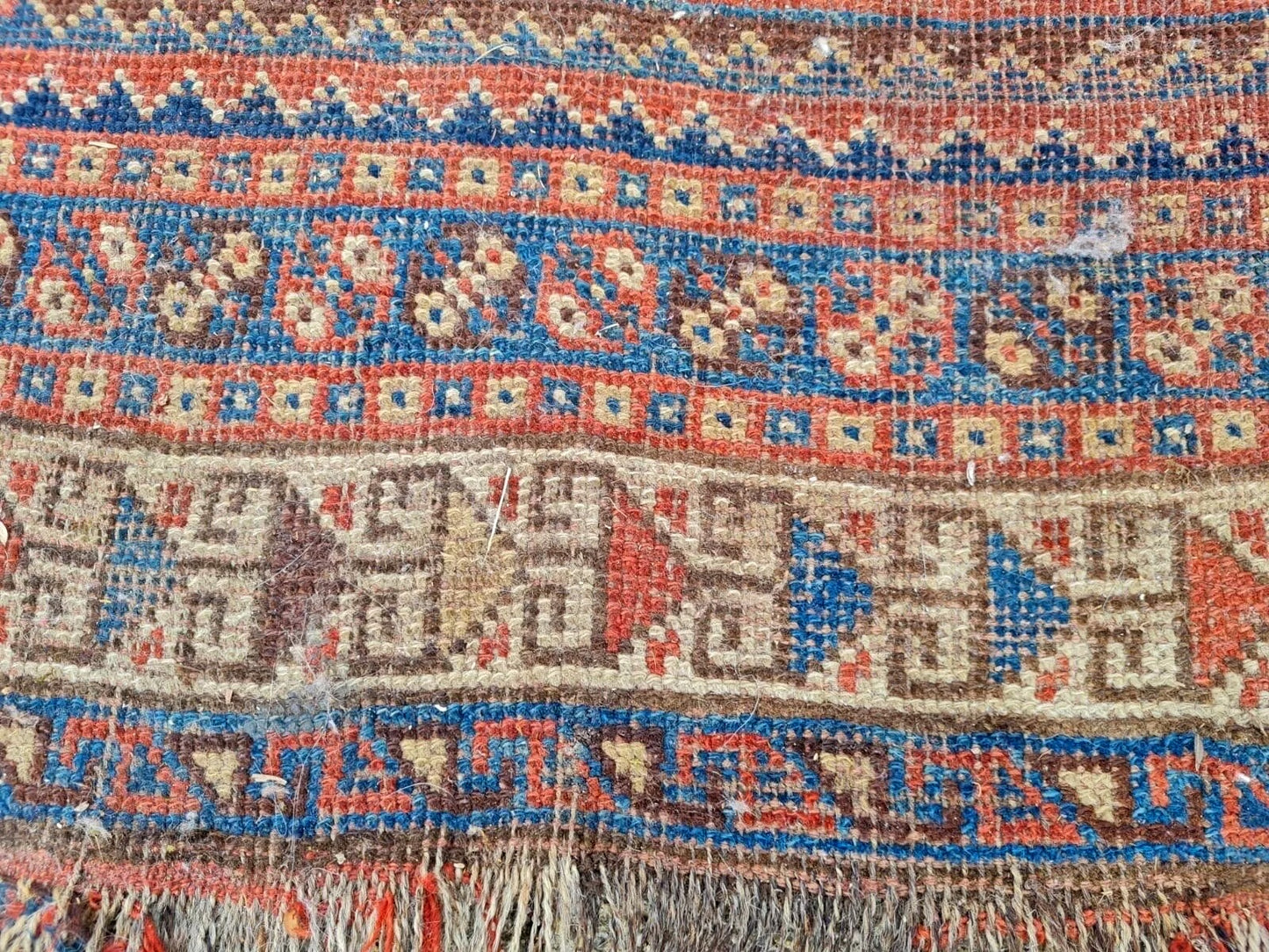 Bold geometric motifs on antique Persian carpet