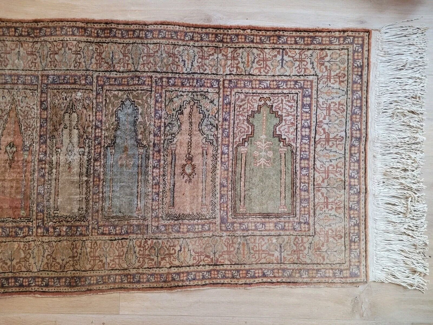 View of symmetrical mihrab motifs on antique runner